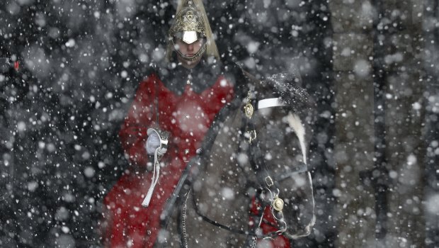 Snow falls on a soldier from the mounted Household Cavalry near Horseguards Parade in central London.