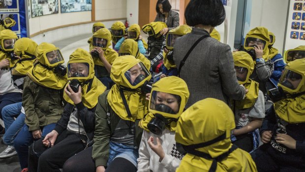 South Korean children learn to use gas masks.