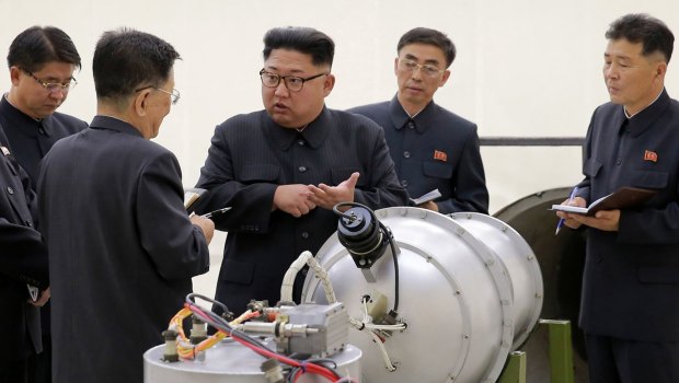 North Korean leader Kim Jong-un examines an explosive device.