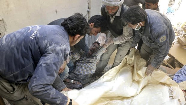 White Helmet rescuers carry a victim after airstrikes and shelling hit in Ghouta, a suburb of Damascus on Wednesday.