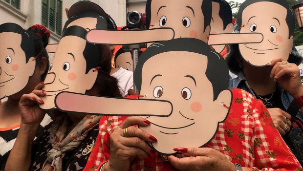 Pro-democracy activists wearing masks mock Thailand's Prime Minister Prayuth Chan-ocha.