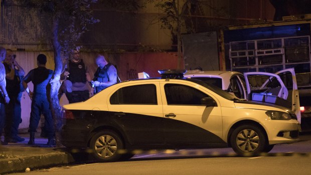 Police officers work next to the car in which Marielle Franco was travelling.