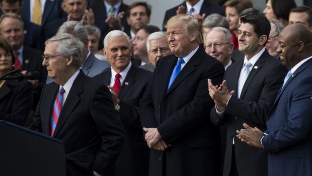 Senate Majority Leader Mitch McConnell, a Republican from Kentucky, left, pauses while speaking as US President Donald Trump, center, listens during a tax bill passage event.