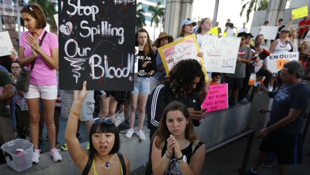 Marylene Dinliana, 18, holds a sign that reads, "Stop Spilling Our Blood" during a protest against guns in Fort Lauderdale.