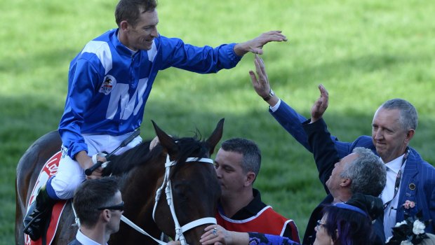 High five: Hugh Bowman celebrates with Peter Tighe after Winx won the Cox Plate.