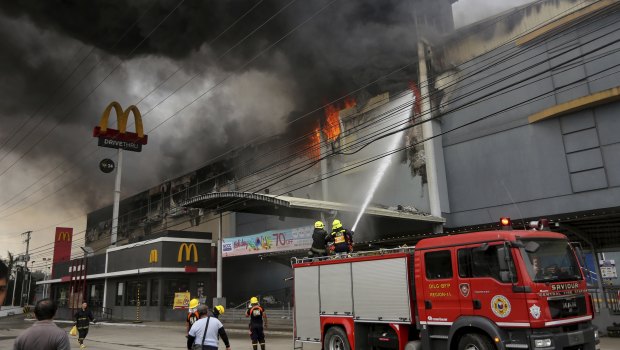 Firemen battle a fire that rages at a shopping mall in Davao city, southern Philippines.