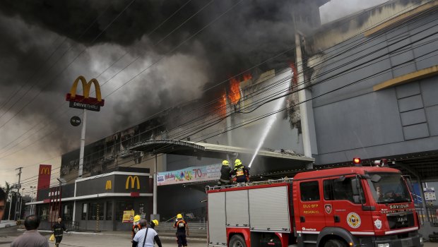 Firemen battle a fire that rages at a shopping mall in Davao city, southern Philippines.