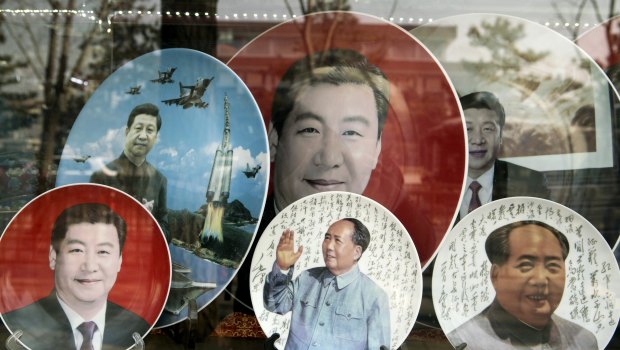 Porcelain plates featuring portraits of former Chinese leader Mao Zedong, bottom second right and bottom right, and Chinese President Xi Jinping are displayed in a shop window in Beijing.