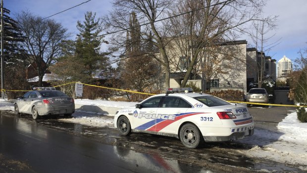 Police cars are parked outside the home of billionaire Barry Sherman in Toronto.