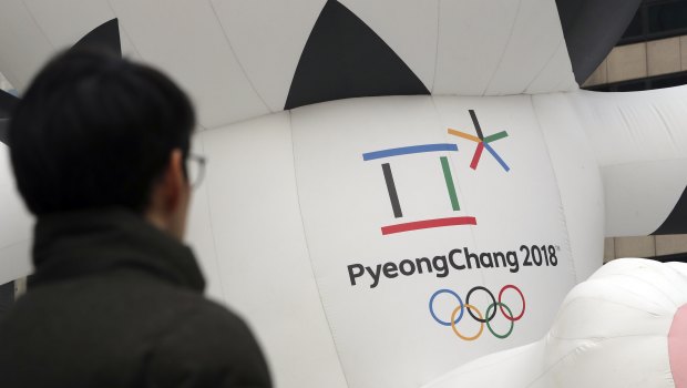 A man walks by the official emblem of the 2018 Pyeongchang Olympic Winter Games, in Seoul, South Korea. 