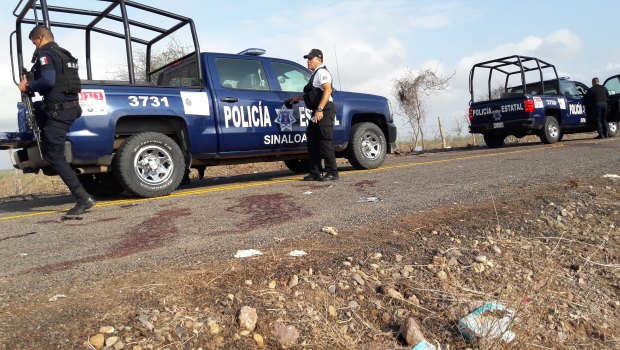 Police officers guard a crime scene after authorities reported a gun battle with armed men near the beach resort of Mazatlan, Mexico in July.