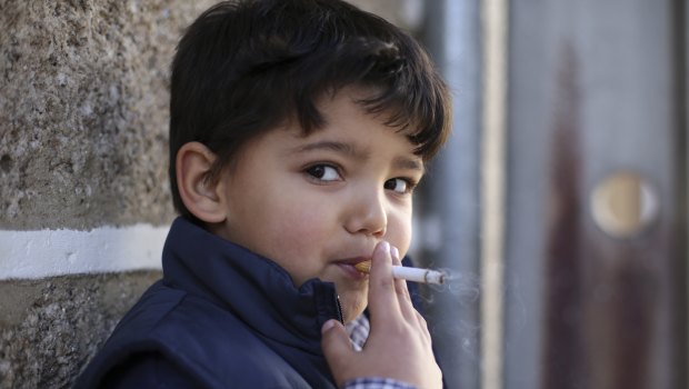 Fernando, 6-years-old, smokes a cigarette in the village of Vale de Salgueiro, northern Portugal, during the local celebration.