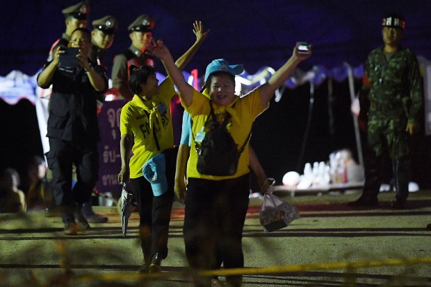 Thai volunteers cheer on news the boys and their coach had been rescued.