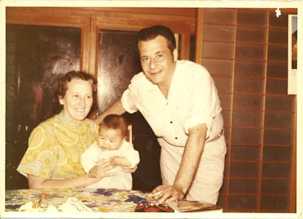 101-year-old Eloise and her husband Michael on one of their many overseas adventures in Japan, holding a local baby.