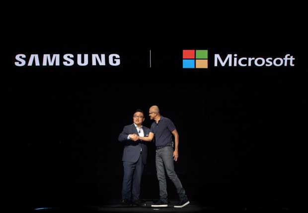 Microsoft CEO Satya Nadella, right, greets DJ Koh, President and CEO of Samsung’s IT & Mobile Communications Division