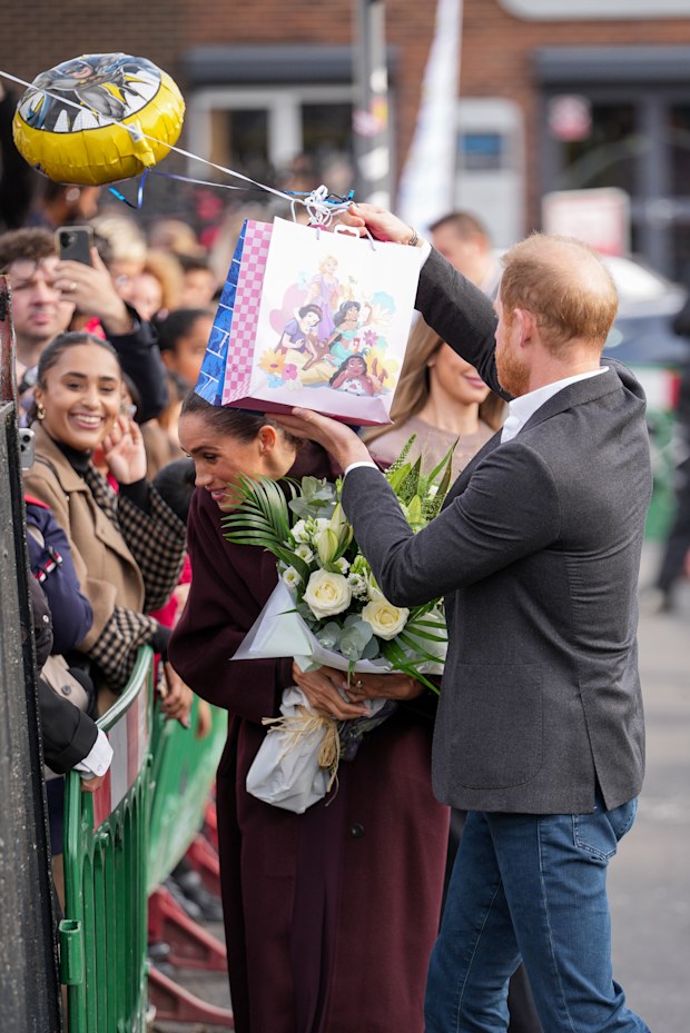 Meghan, Duchess of Sussex and Prince Harry, Duke of Sussex receive gifts from well-wishers as they arrive at the Community Recording Studio (CRS), 