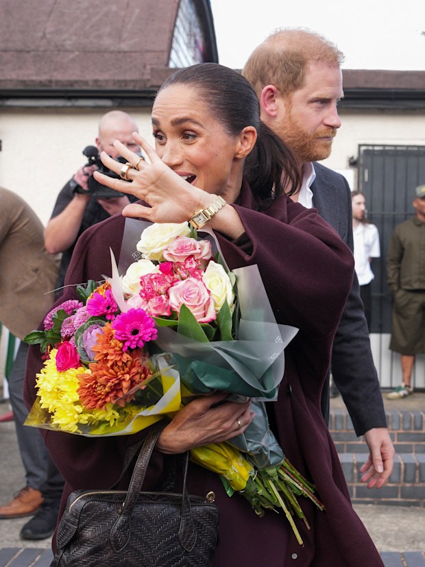Meghan, Duchess of Sussex holds a bouquet of flowers as she and Prince Harry, Duke of Sussex leave the Community Recording Studio (CRS), a youth and community charity 