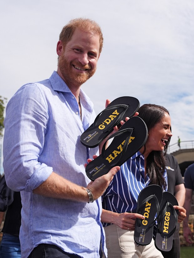 Prince Harry, Duke of Sussex and Meghan, Duchess of Sussex receive flip-flops with the inscriptions "G'day Hazza" and "G'day Megs" at a sailing event with members of Invictus Australia in Sydney Harbour, on day four of the royal trip on April 17, 2026 in Sydney, Australia. 
