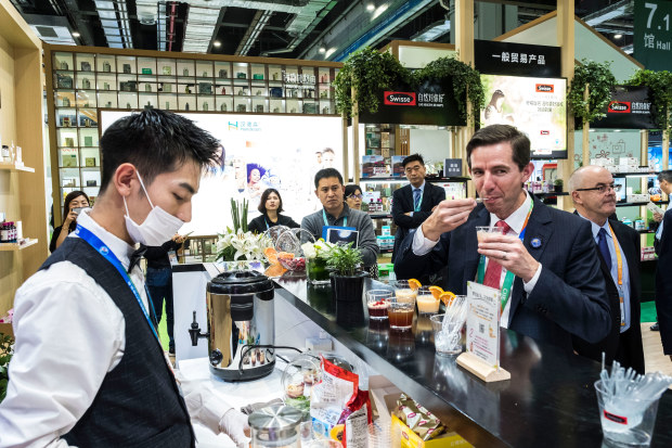 Trade Minister Simon Birmingham trying vitamin drinks at the Swisse stand on day one of the China International Import Expo in Shanghai last year. 