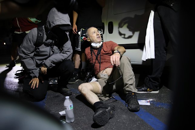 Protesters help ​photographer Nick Stern after he was shot with ‍a plastic bullet.