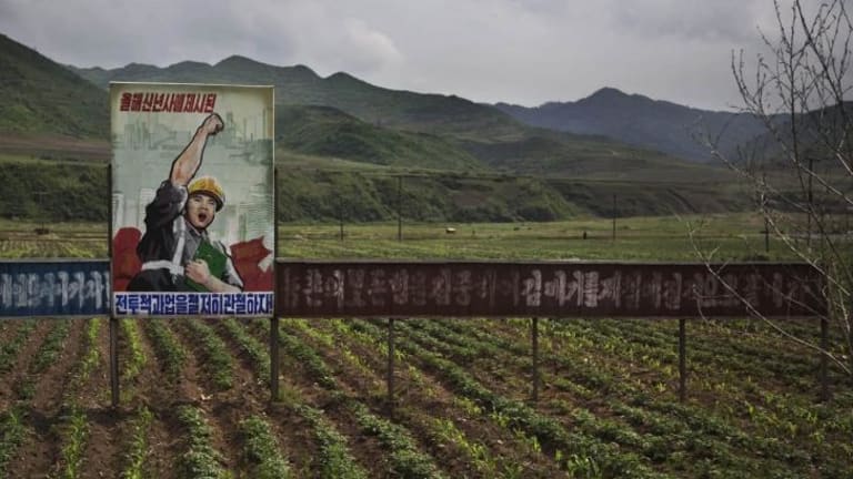 A propaganda billboard stands in a field south of Samsu, in North Korea's Ryanggang province.