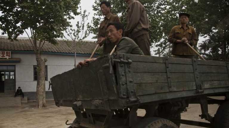 North Korean men ride in a farmer's wagon in North Korea's South Hamgyong province. North Korea has struggled to obtain tractor fuel for more than two decades.