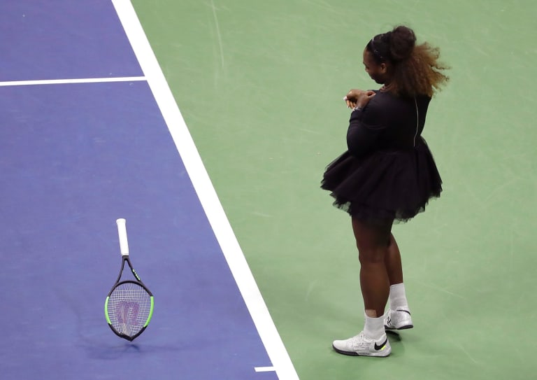 Serena Williams smashes her racket.
