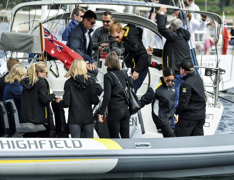 Getting cramped. Prince Harry, top center, and his wife Meghan, second from right, sail on Sydney Harbor during the Invictus Games last Sunday.