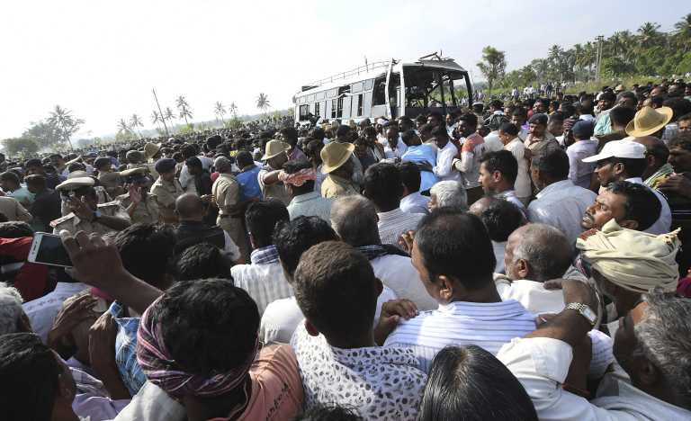 A crowd gathers around the bus that was pulled from the canal.