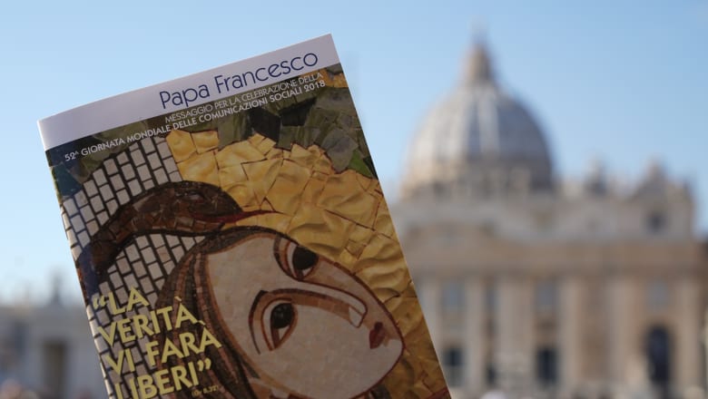 Pope Francis' book on "Fake News" in front of St Peter's Basilica in Rome.