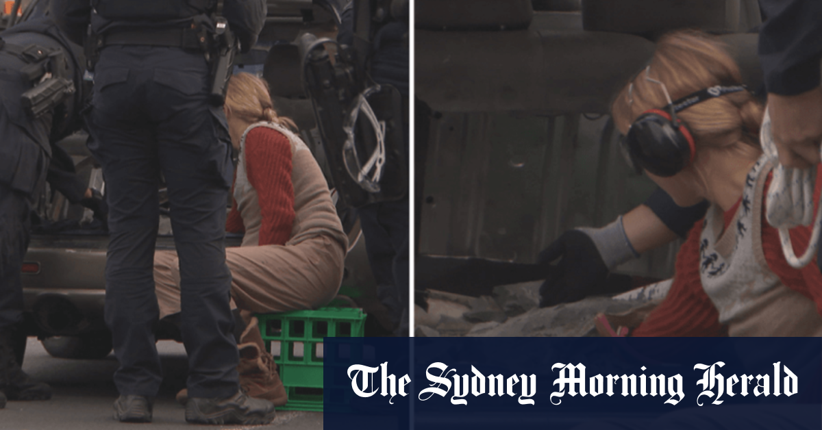 Video Woman chains herself to car in Melbourne protest