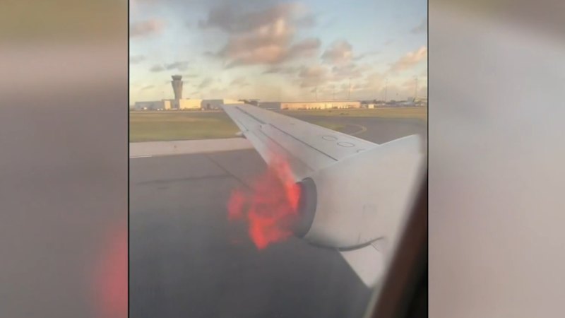 Passengers look out window to see plane on fire