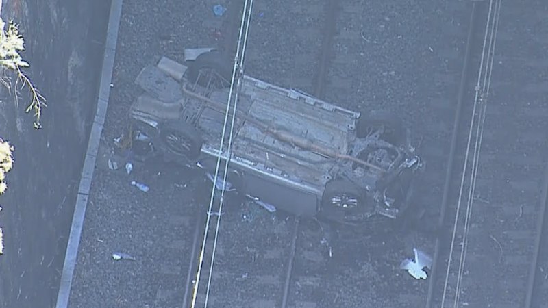 Car crashes onto train tracks west of Sydney