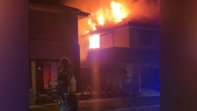 Two men fighting for life, woman in hospital under police guard after house fire