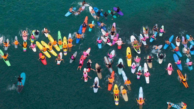 Family and friends paddle out for shark attack victim