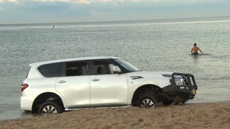 Bulldozer removes bogged car from Melbourne beach