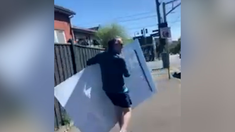 Monique Ryan's husband appears to remove a sign supporting her Liberal rival.