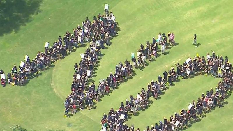 Protestors form giant human ‘no’ at proposed Brisbane Olympic site