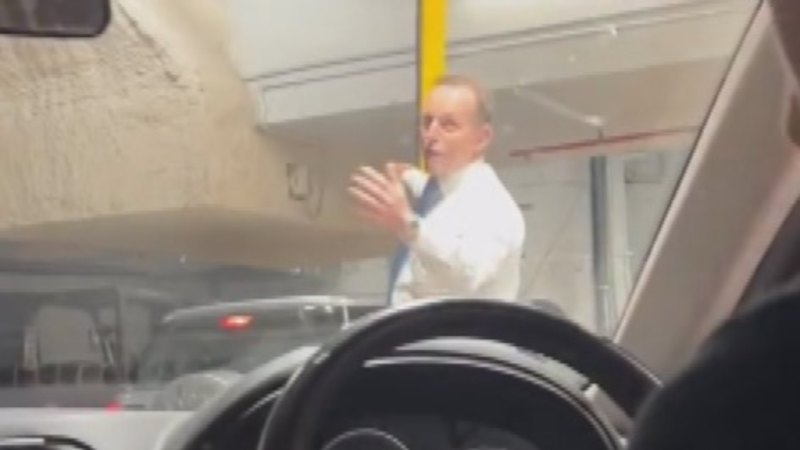 Former Prime Minister Tony Abbott operates directs traffic in car park