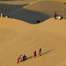 Residents walk on sand dunes in the Libyan desert oasis town of Ghadames
