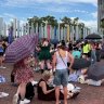 Fans sing along to a Taylor Swift busker as they wait for merch stands to open