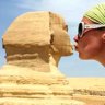 Woman pretending to kiss the Sphinx, Egypt. Solo travel.