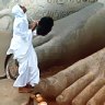 Piety prevails ... a Jain pilgrim prays at the feet of the statue of Gommateshwara.