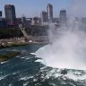 The town of Niagara Falls, Canada is seen past a cloud of mist rising over Horseshoe Falls, the largest of the Niagara Falls 