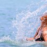 Woman tosses back her wet hair while bathing in Muri Lagoon.