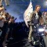 Tom Cruise rides motorbike with Olympic flag out of closing ceremony