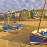 Strange cloud formation in the early morning with small Cornish fishing boats at low tide in the harbour at St. Ives, Cornwall, England.