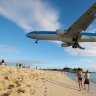 Sint Maarten a plane flies low over Maho Beach into the airport.