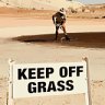 A local rakes out the green of the Coober Pedy Golf Course