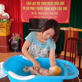 An expectant mother practices bathing her baby as part of the Learning Club project in Vietnam, pioneered by Australian researchers in Vietnam.